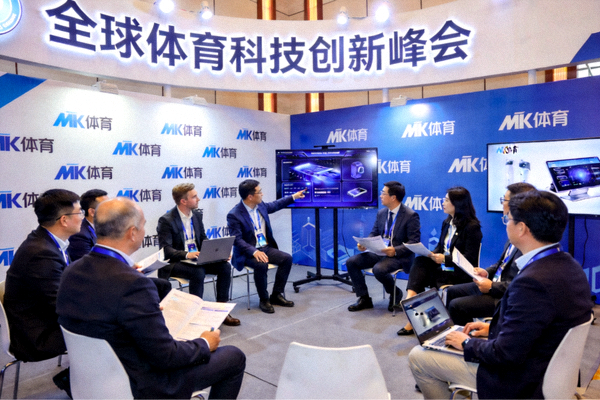 全球体育科技创新峰会会场，MK体育品牌背景板与参会嘉宾交流场景